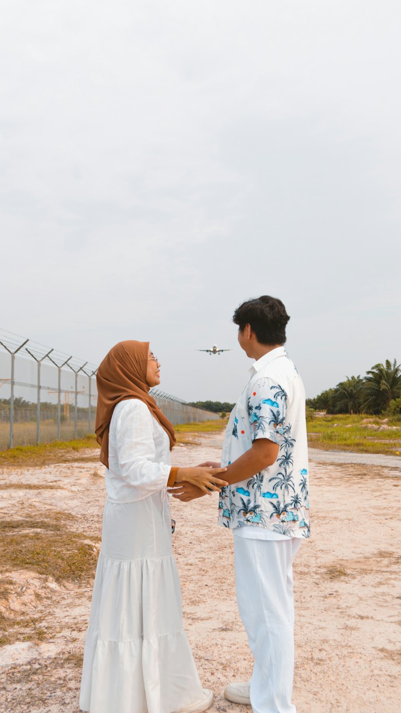 A couple holding hands as a plane flies overhead