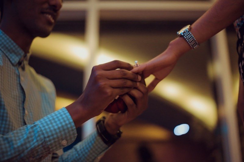An engagement ring being placed on a hand